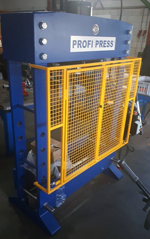 100-ton workshop press with wire protective cage, front doors swing open.